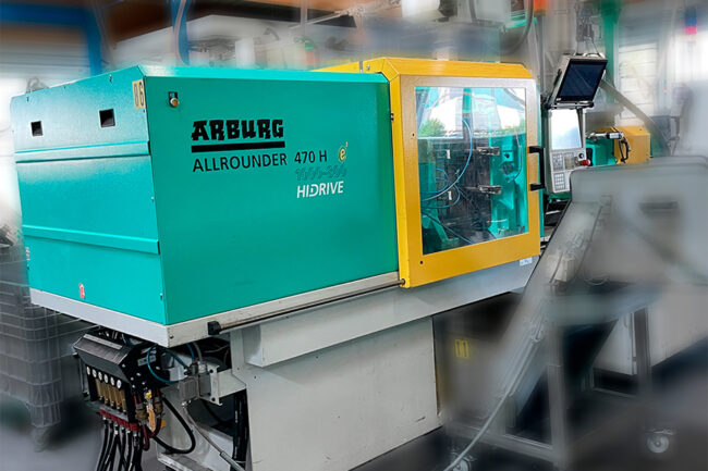 A single Arburg injection moulding machine in a production hall, zoomed in